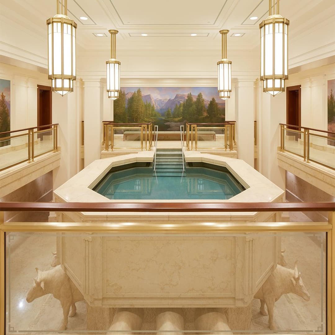 Interior view of the Meridian Idaho Temple baptismal font with oxen and mural.