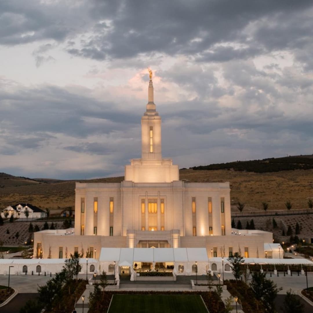 Exterior front view of the Pocatello Idaho Temple illuminated at dusk.