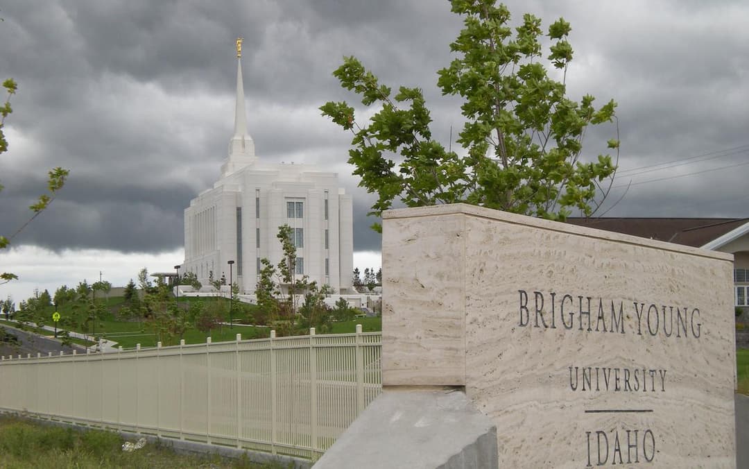 Rexburg Idaho Temple and BYU-Idaho sign under overcast sky.