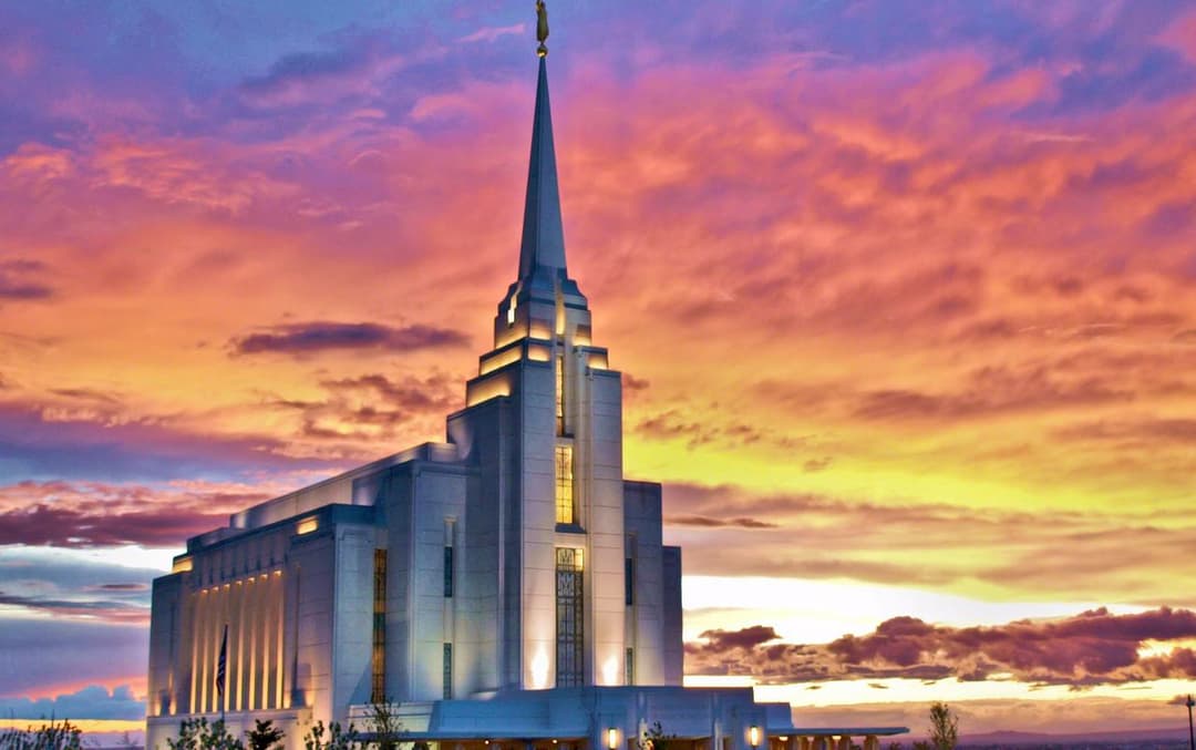 Rexburg Idaho Temple exterior at twilight, colorful clouds.