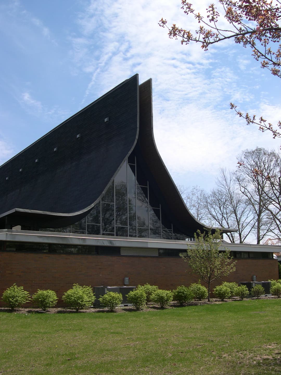 Exterior daytime view showing the dramatic sweeping curved roofline.