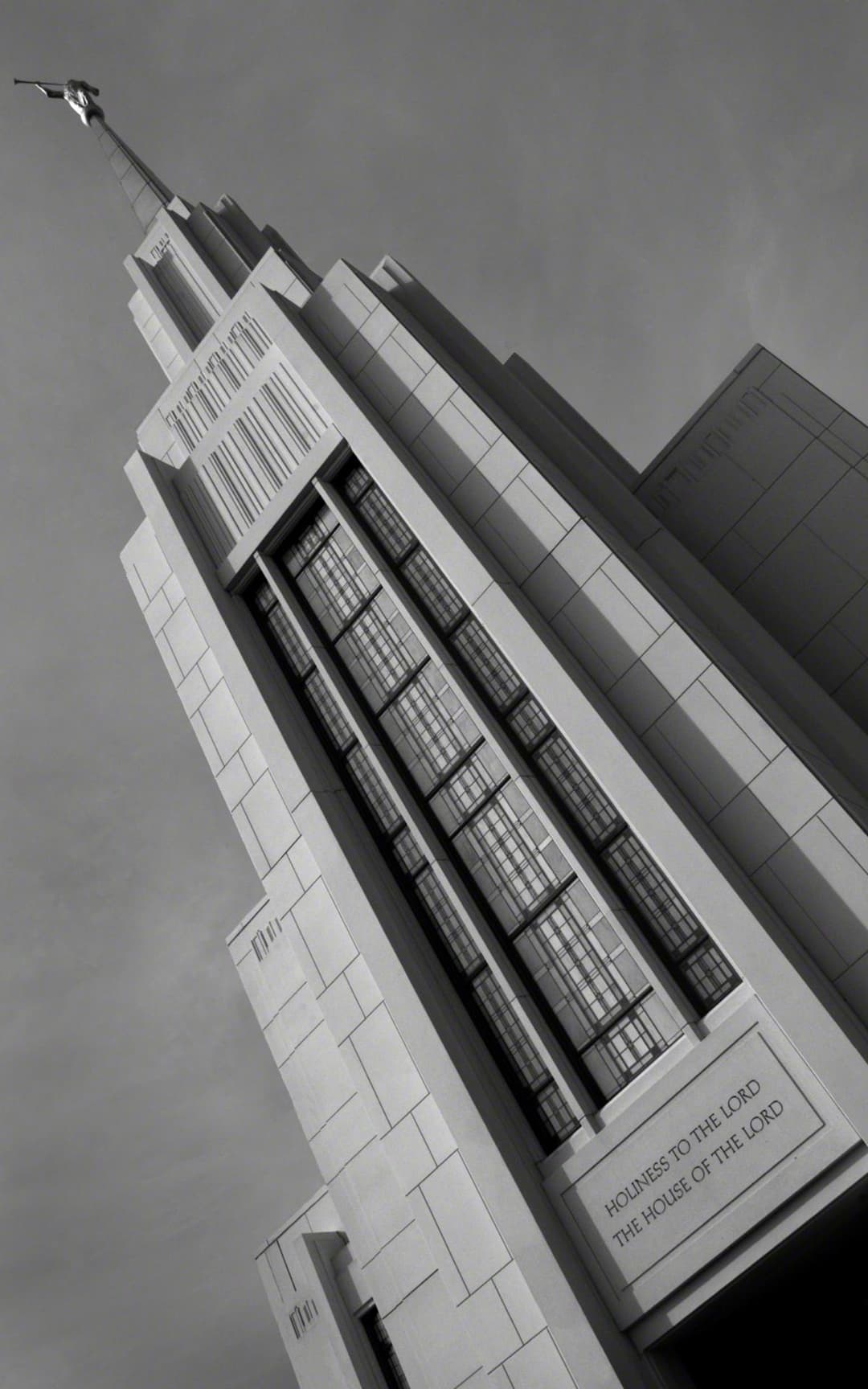 Low-angle monochrome view of the temple spire and facade.