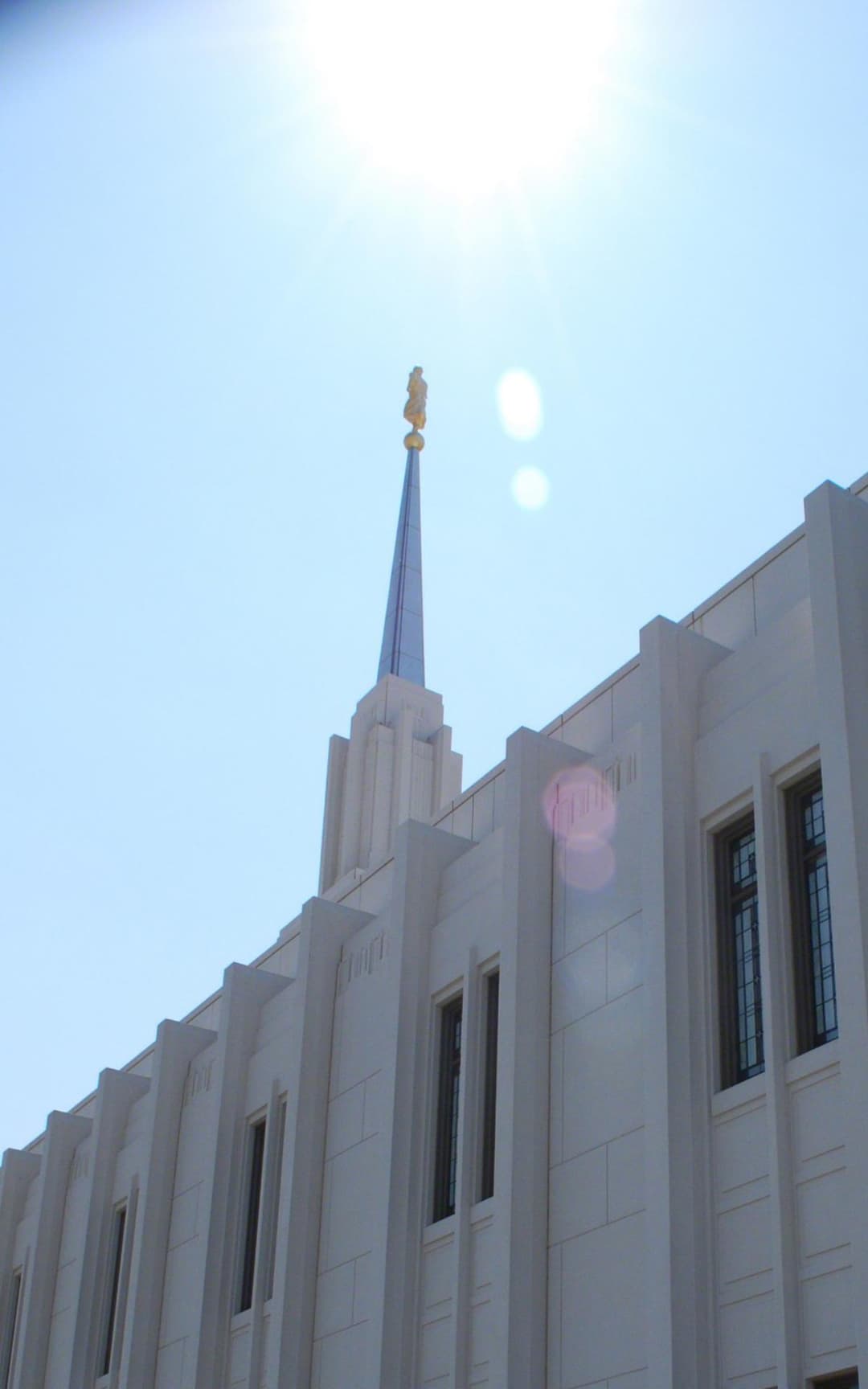 Low-angle view of the exterior facade and spire in bright sunlight.