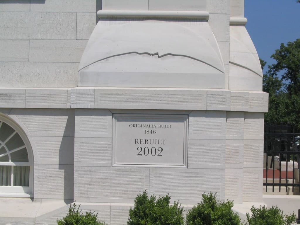 Close-up of the temple's exterior stone and "rebuilt 2002" plaque.
