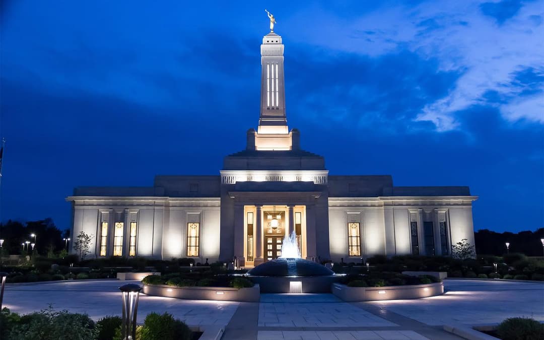 Indianapolis Indiana Temple at twilight, front view with spire and fountain.