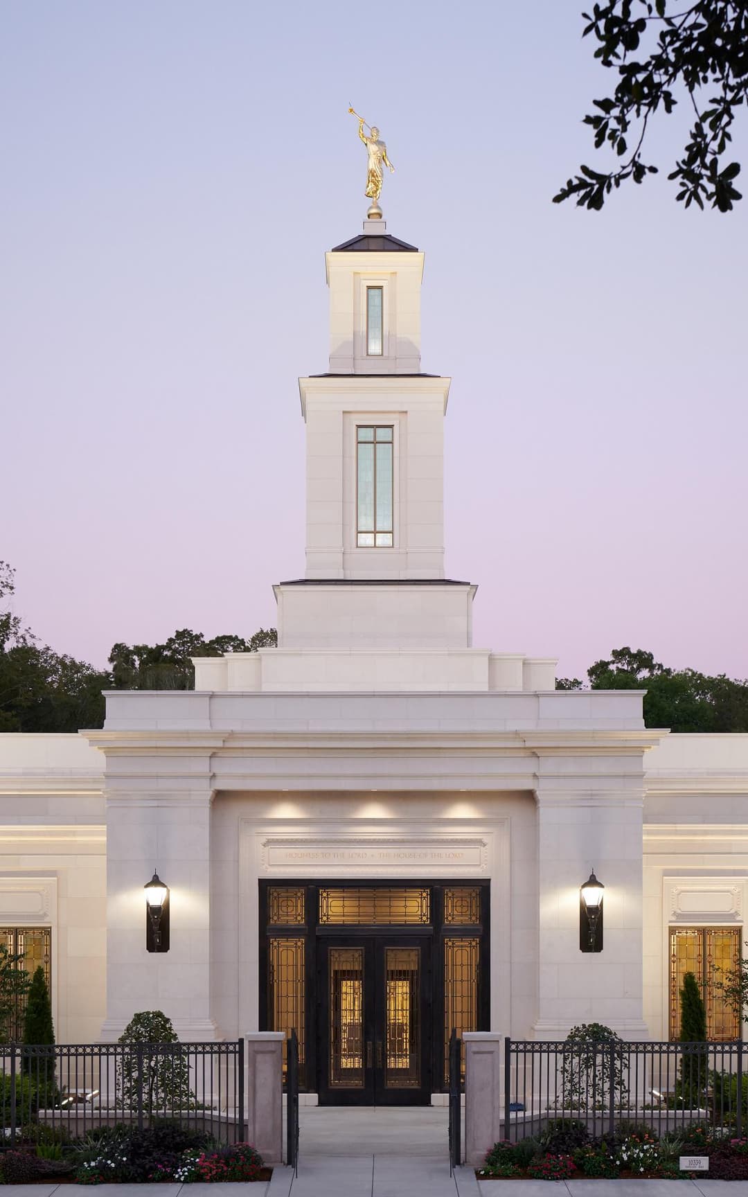 A wide-angle view of the temple grounds, featuring manicured lawns and vibrant flowerbeds.