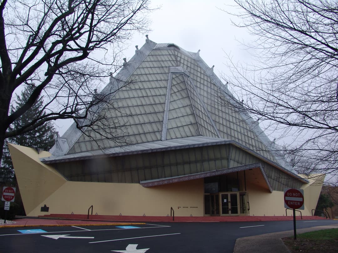 Exterior view of the front entrance and soaring pyramidal roof.