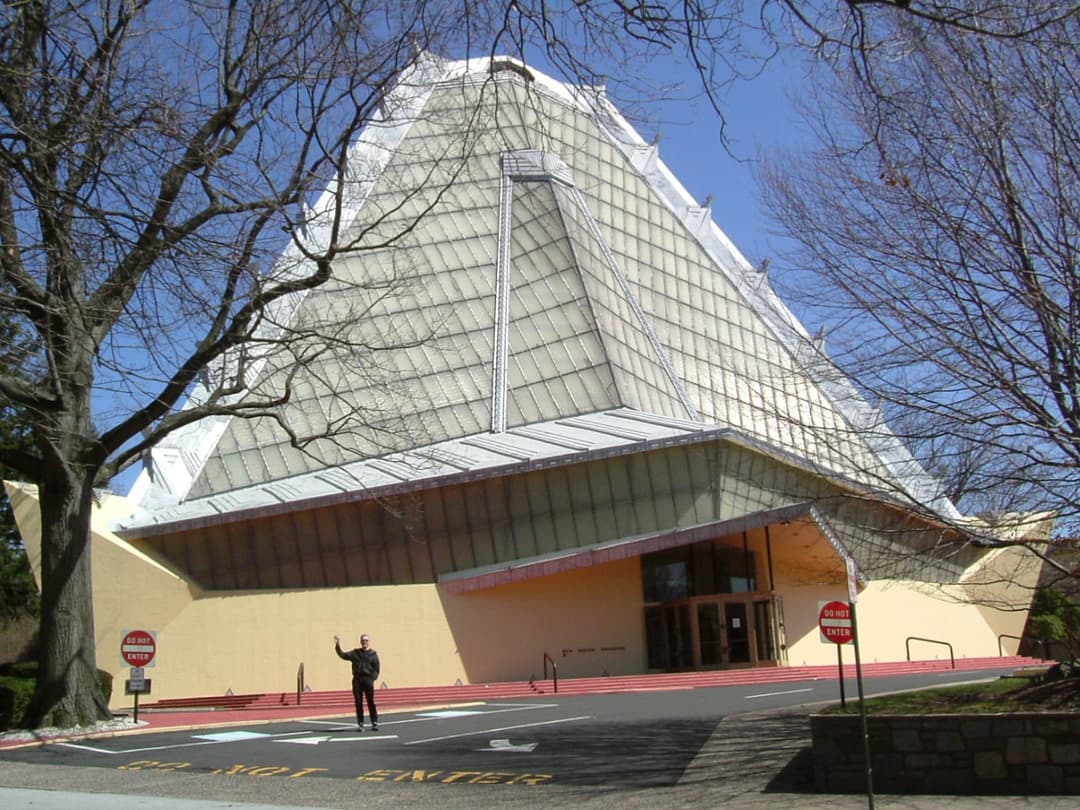 Exterior view of the front entrance and towering pyramidal glass roof.