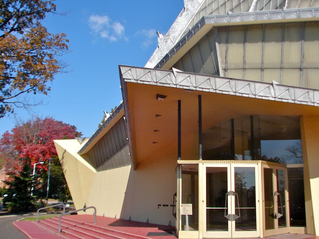 Exterior view of the front entrance and geometric canopy in daylight