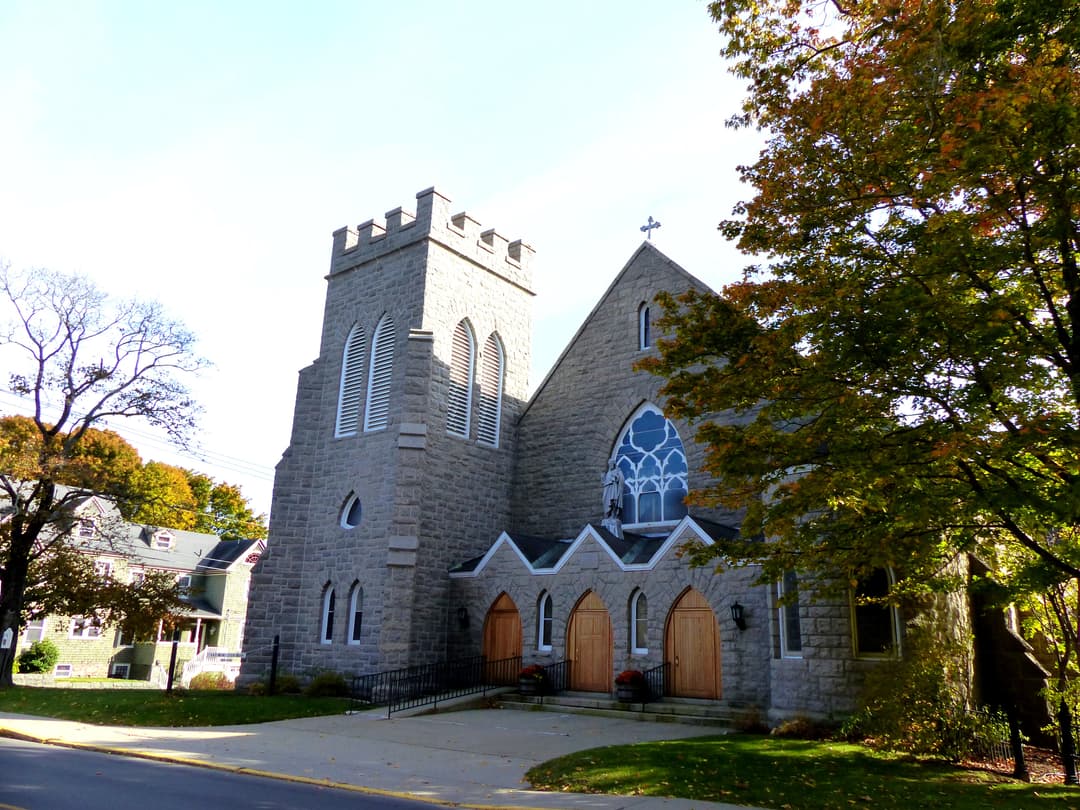 Exterior view of the stone church and crenellated bell tower