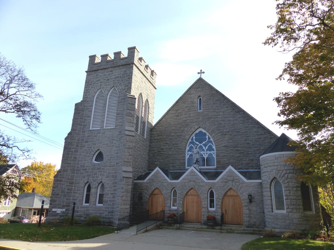 Exterior view of the stone church facade with crenellated tower