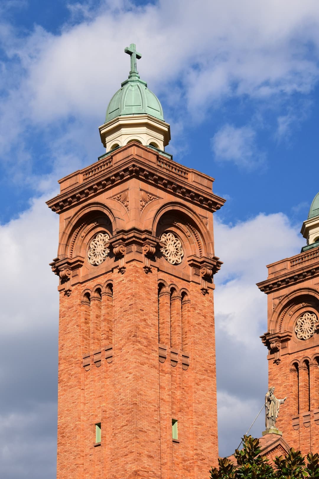 Detail of the ornate brick bell tower and copper dome against a blue sky