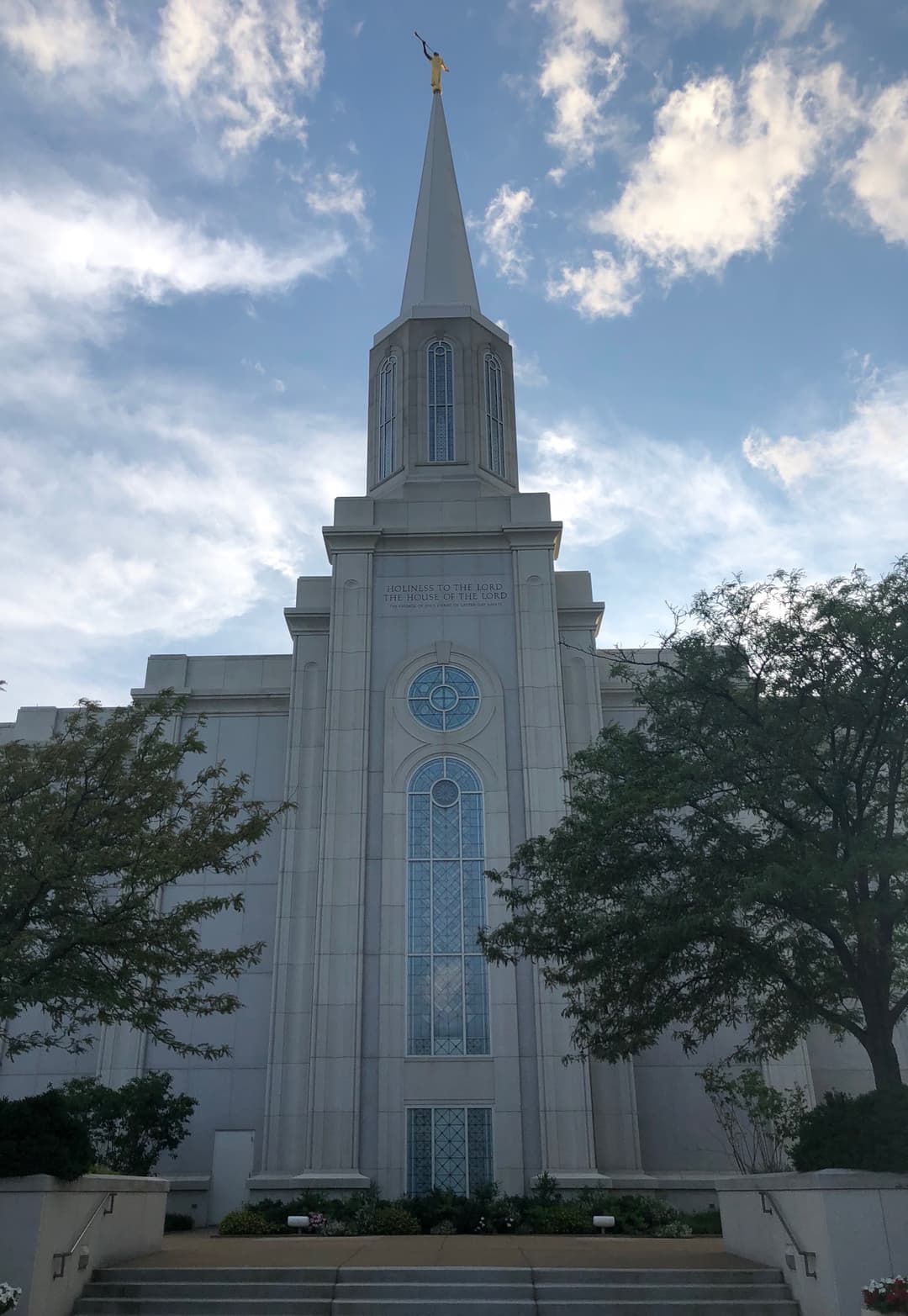 Low-angle front view of the temple façade and single spire.