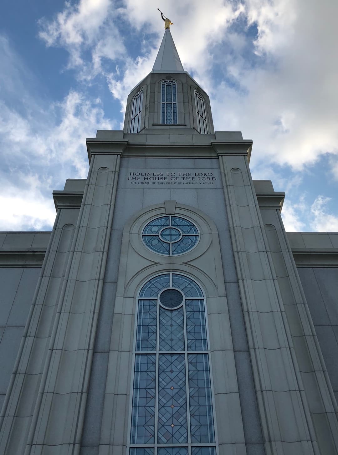 Low-angle view of the St. Louis Missouri Temple facade, inscription, and spire.