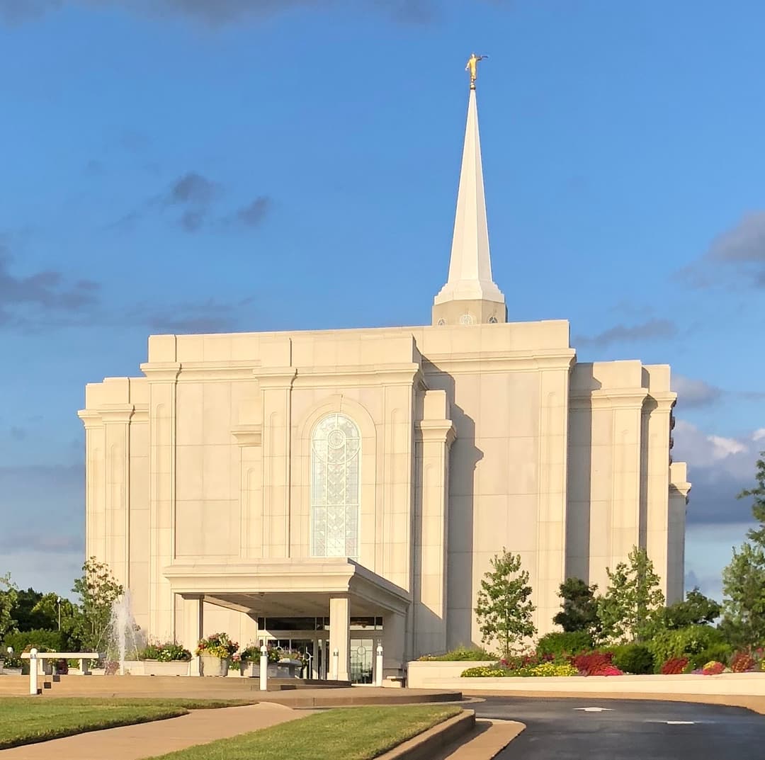 Front entrance and spire of the St. Louis Missouri Temple in warm sunlight.