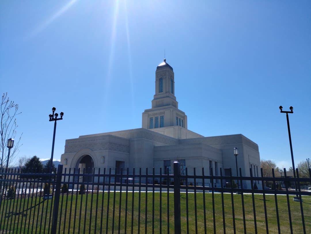 Helena Montana Temple exterior, low-angle, with fence and sun flare.