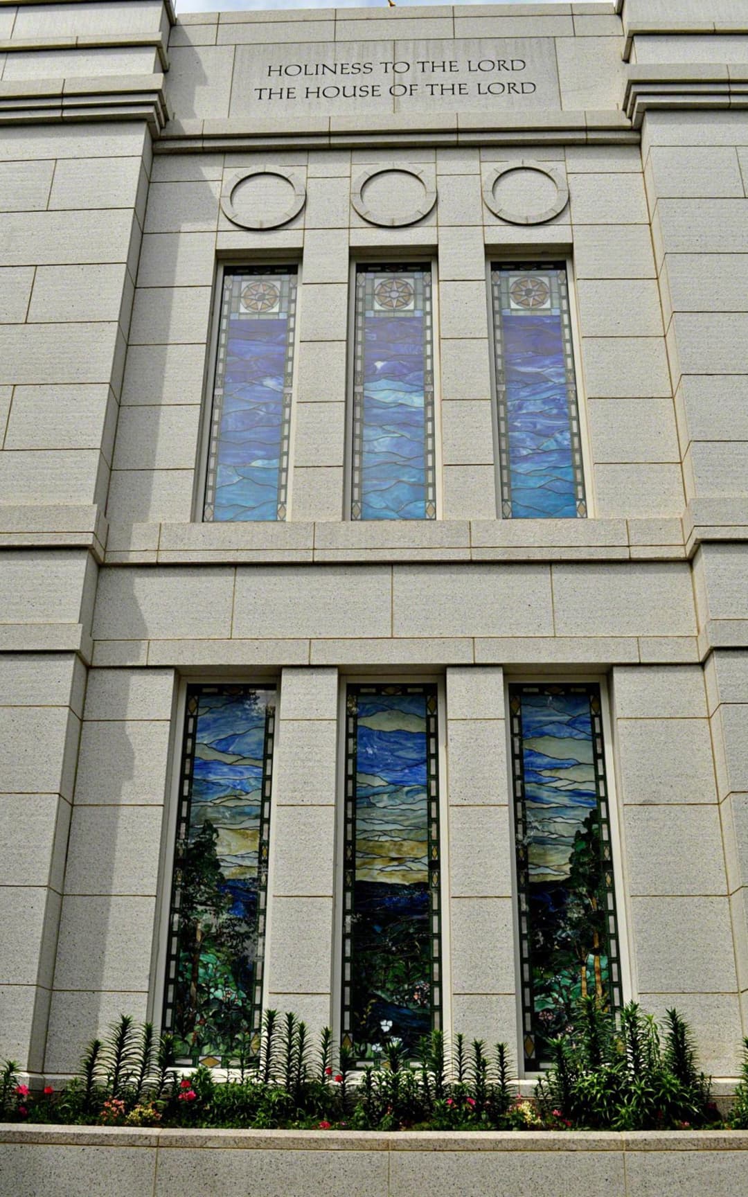 Exterior detail of the stained-glass windows and inscription.