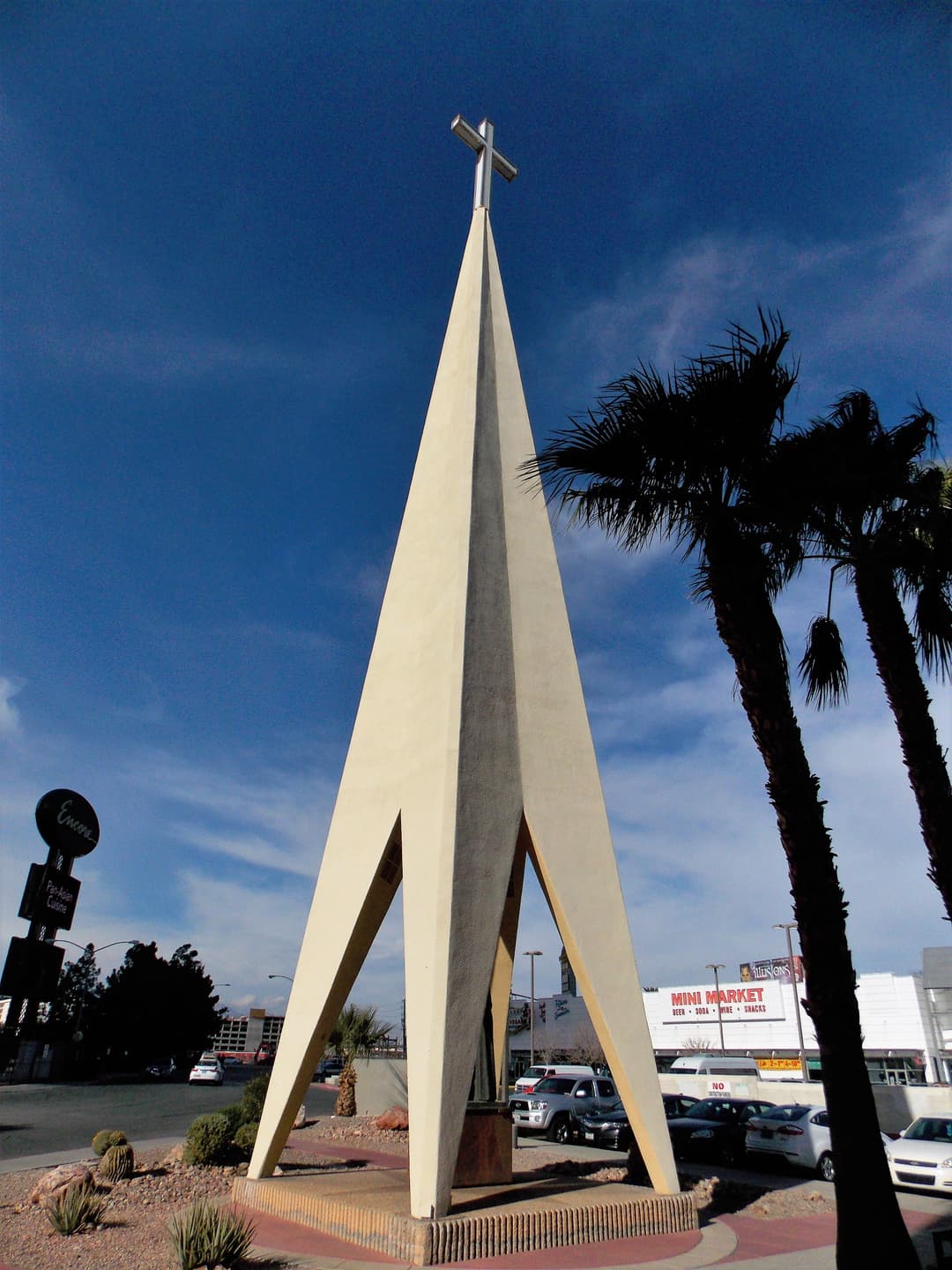 Low-angle daytime view of the cathedral's concrete spire and cross.