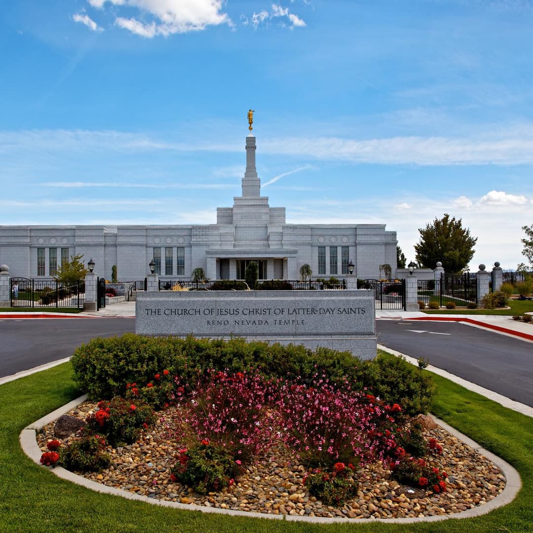 Front view of the Reno Nevada Temple with monument sign and flower garden.