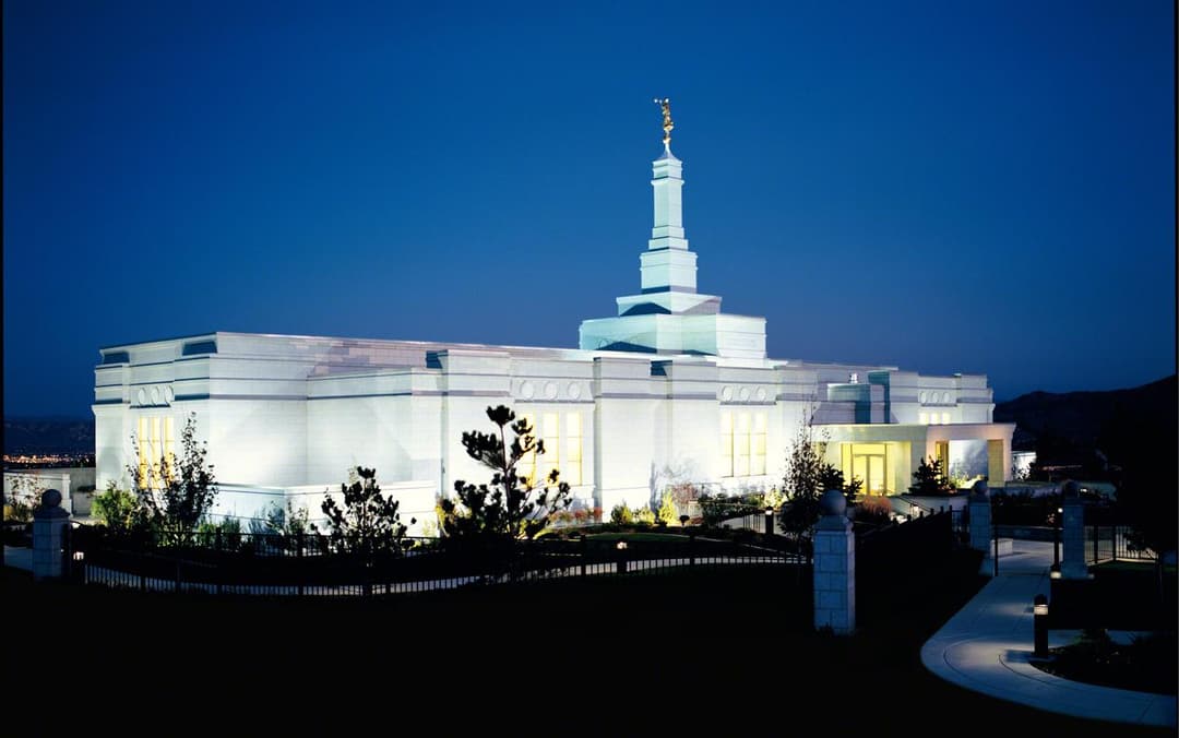 Exterior view of the illuminated Reno Nevada Temple at twilight.