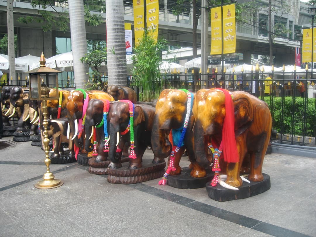 Votive carved wooden elephant statues decorated with colorful garlands