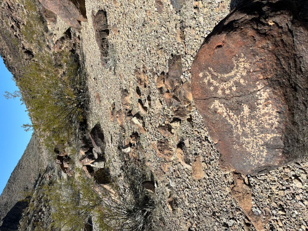 Daylight view of petroglyphs etched into a volcanic boulder in Sloan Canyon.