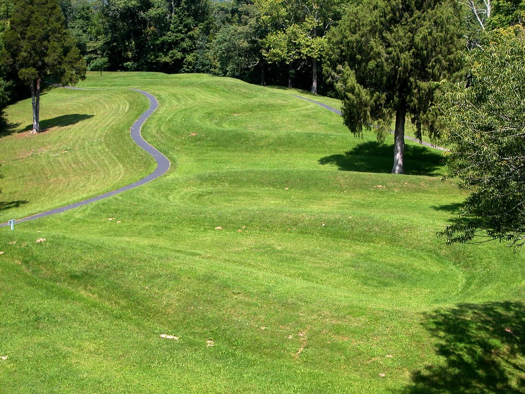 Elevated view of the grassy effigy earthwork coils and paved walkway.