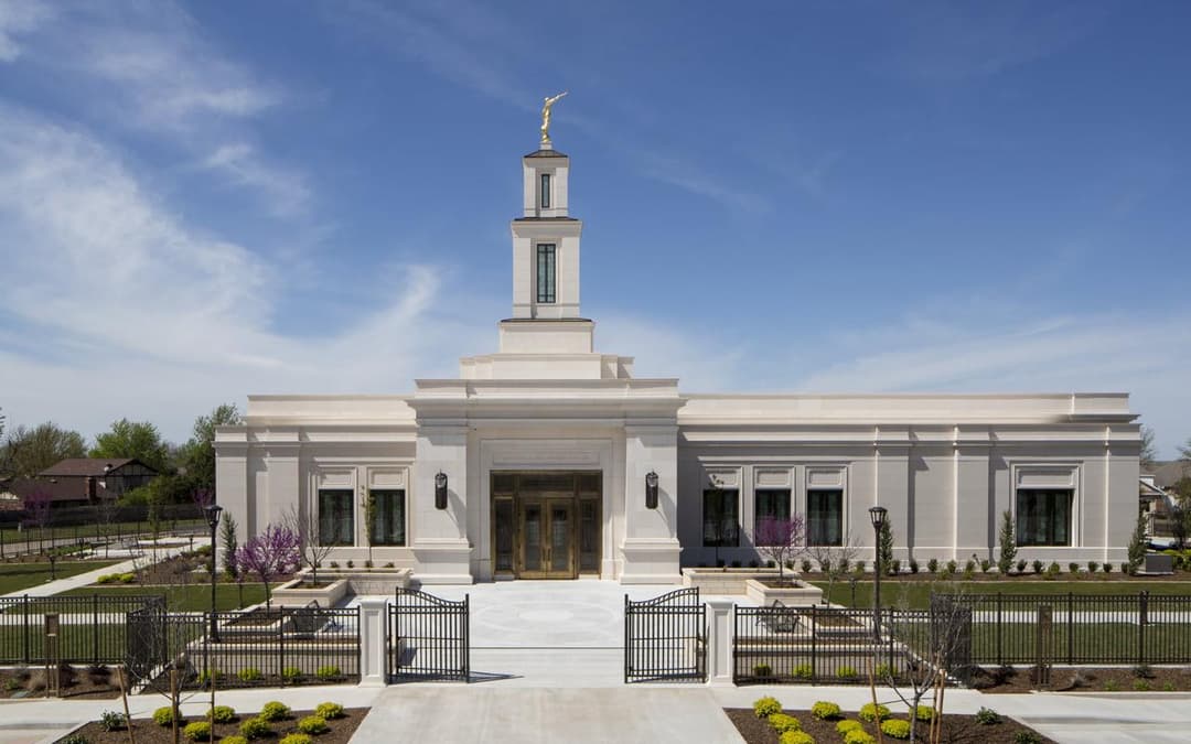 Front view of Oklahoma City Temple with spire, Angel Moroni, and grounds.
