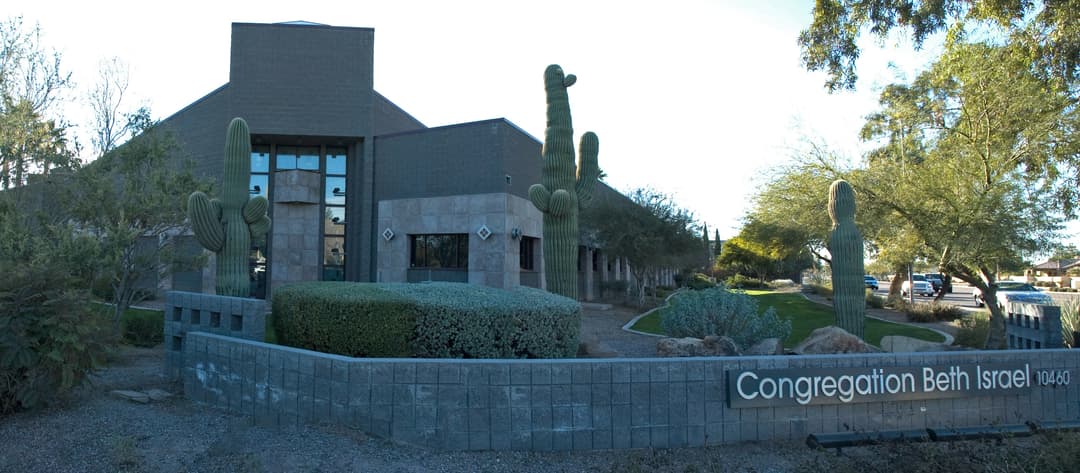 Exterior view of Congregation Beth Israel entrance sign and saguaro cacti