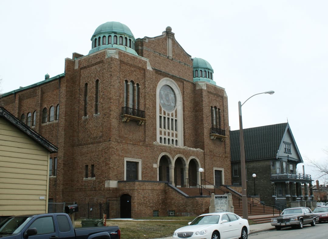 Front exterior view of the brick facade with twin copper domes.