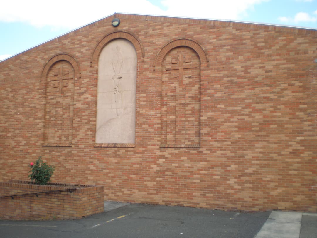 Exterior wall featuring arched niches and central torch relief