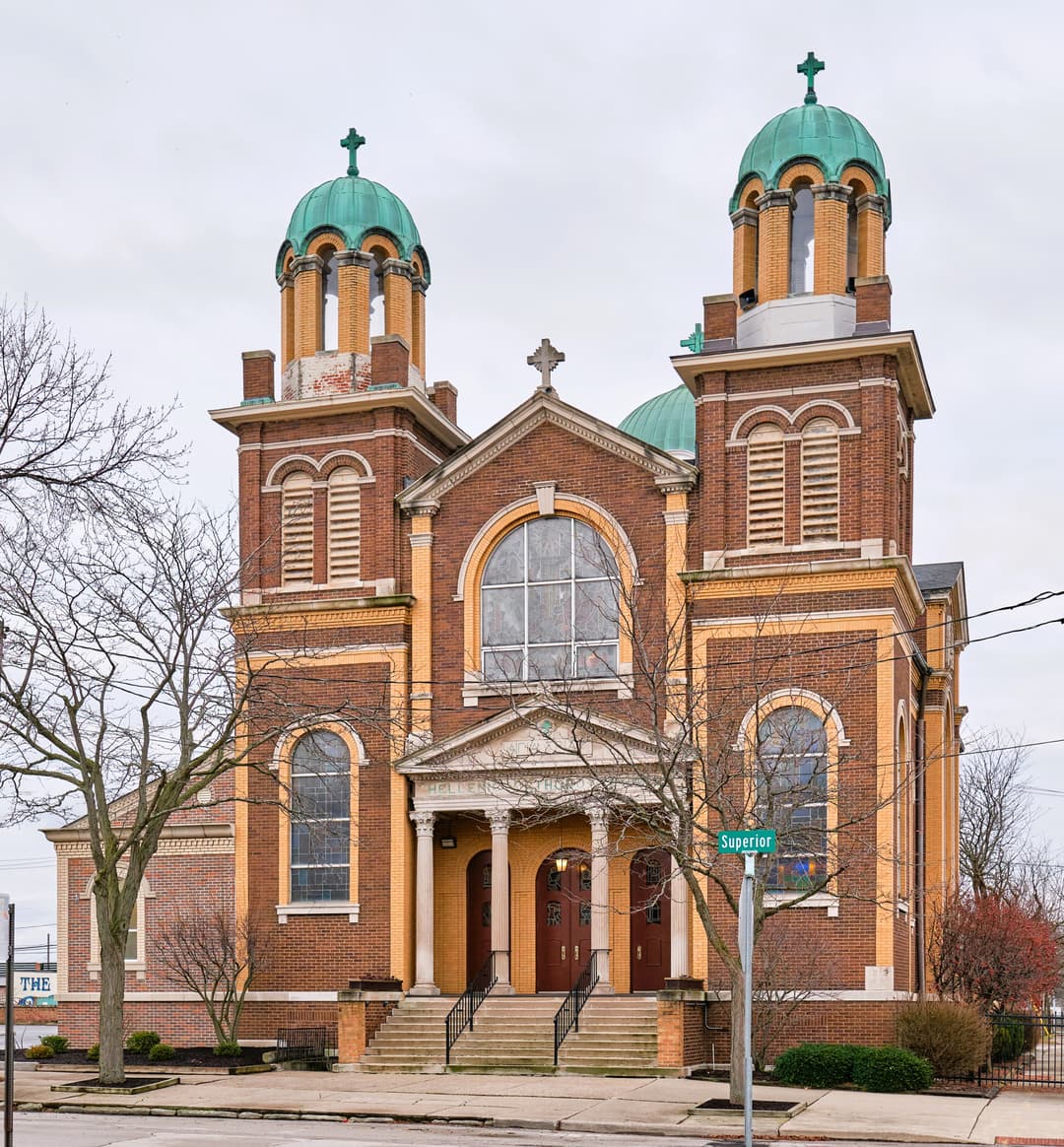 Front facade with twin copper-domed bell towers and entrance portico.