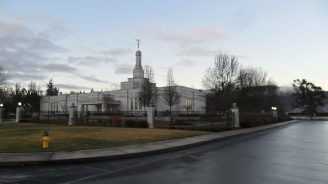 Medford Oregon Temple exterior at twilight, with spire and Angel Moroni.