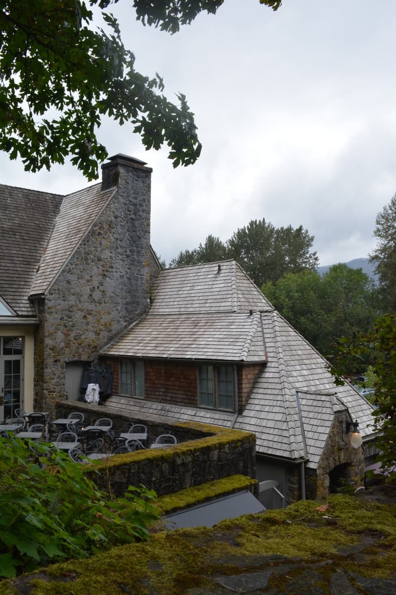 High-angle exterior view of the rustic stone lodge and patio.