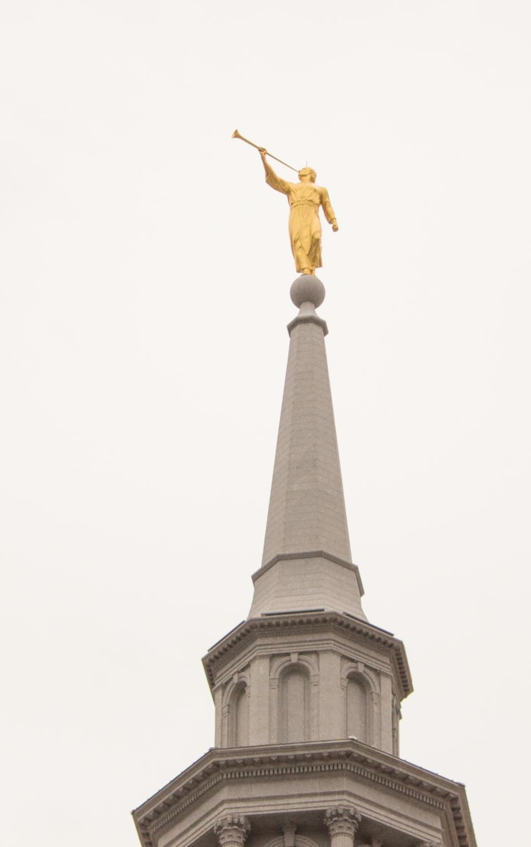 Close-up of the golden Angel Moroni statue atop the granite spire.