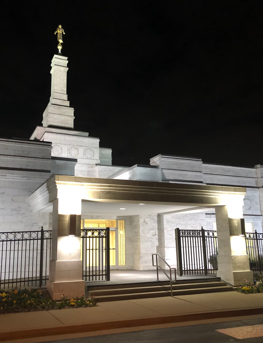 Illuminated entrance and spire of the Nashville Tennessee Temple at night.