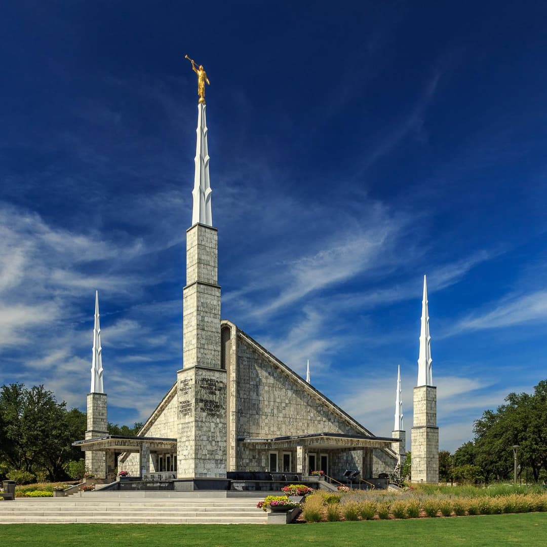 The Dallas Texas Temple glowing in warm evening light, its marble facade catching the sunset.