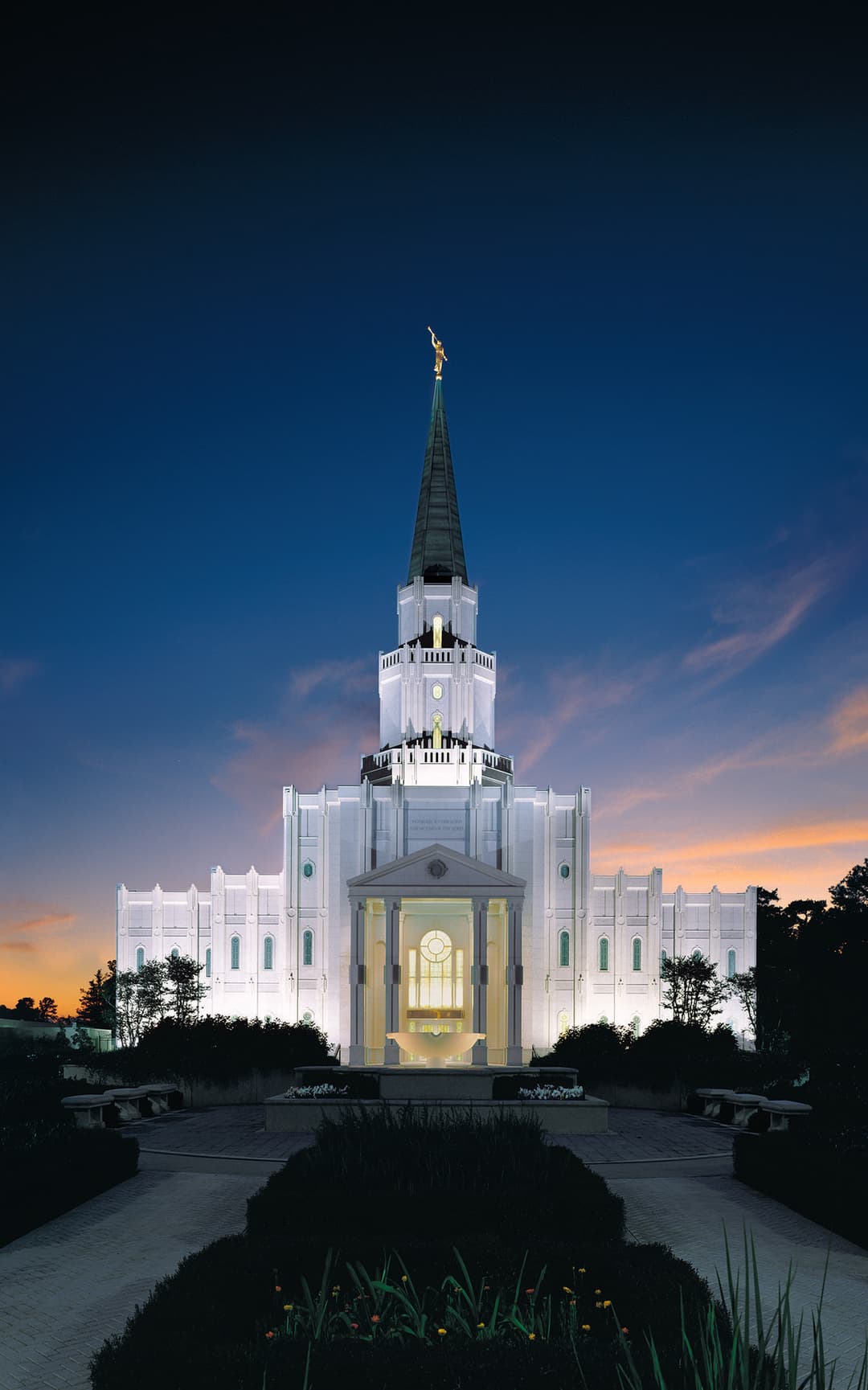 Front view of the Houston Texas Temple illuminated at twilight.