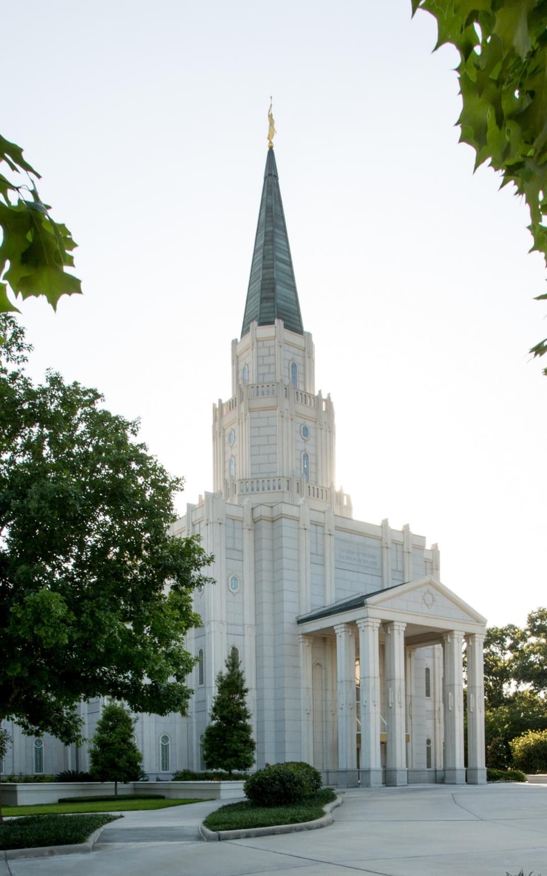 Low-angle view of the Houston Texas Temple front entrance and spire.