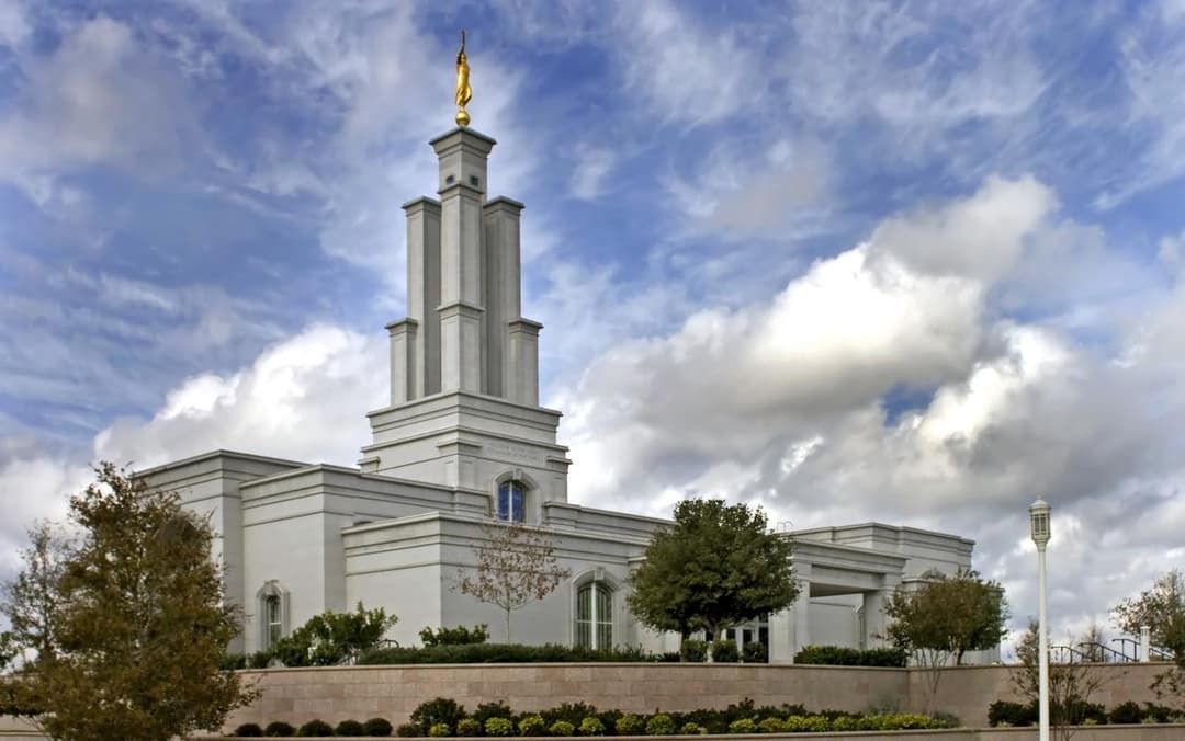 Exterior view of the San Antonio Texas Temple and spire under a cloudy sky.