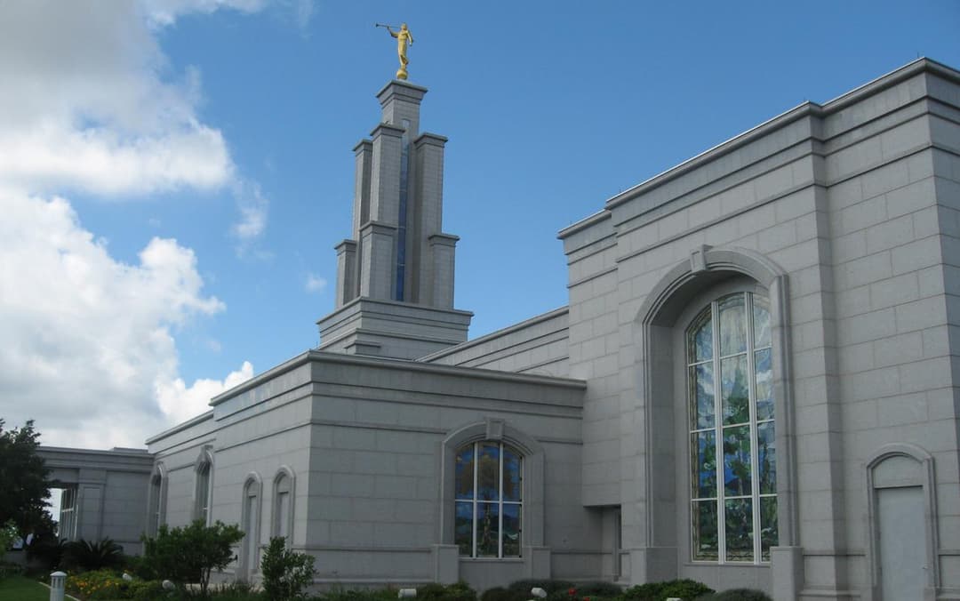 Low-angle view of the granite facade, spire, and stained-glass windows.