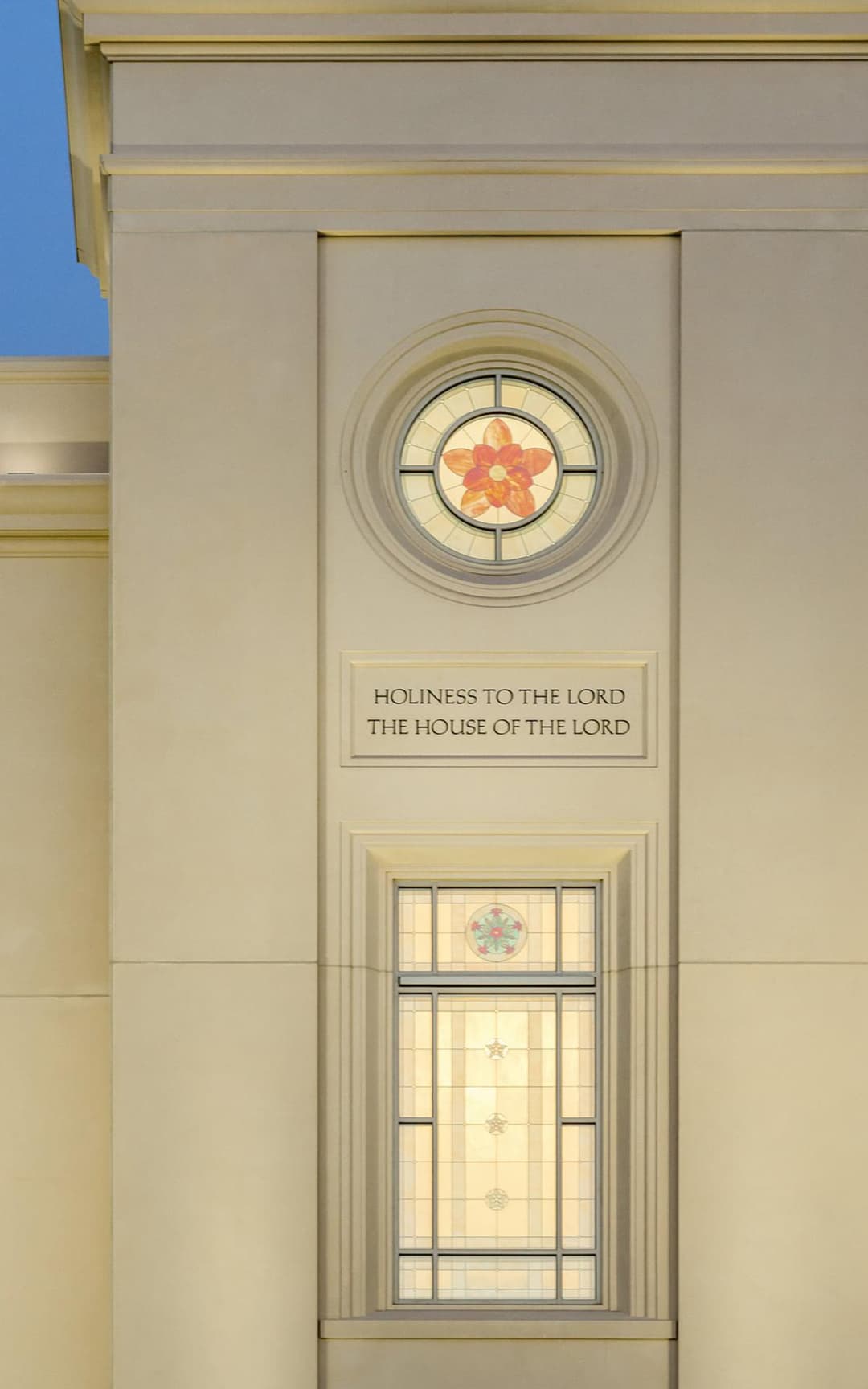 Exterior detail of the temple inscription and stained glass at twilight.