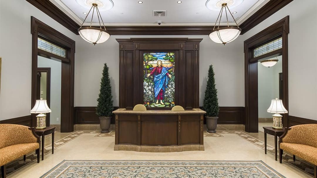 Interior view of the recommend desk and stained-glass window of Christ.