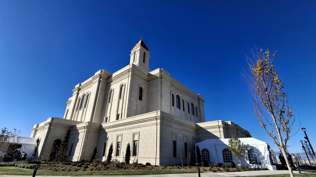 Low-angle wide shot of the Deseret Peak Utah Temple under a clear blue sky.