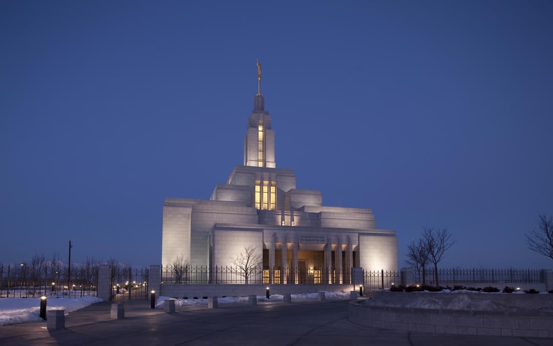 Draper Utah Temple at twilight, illuminated front view, single spire.