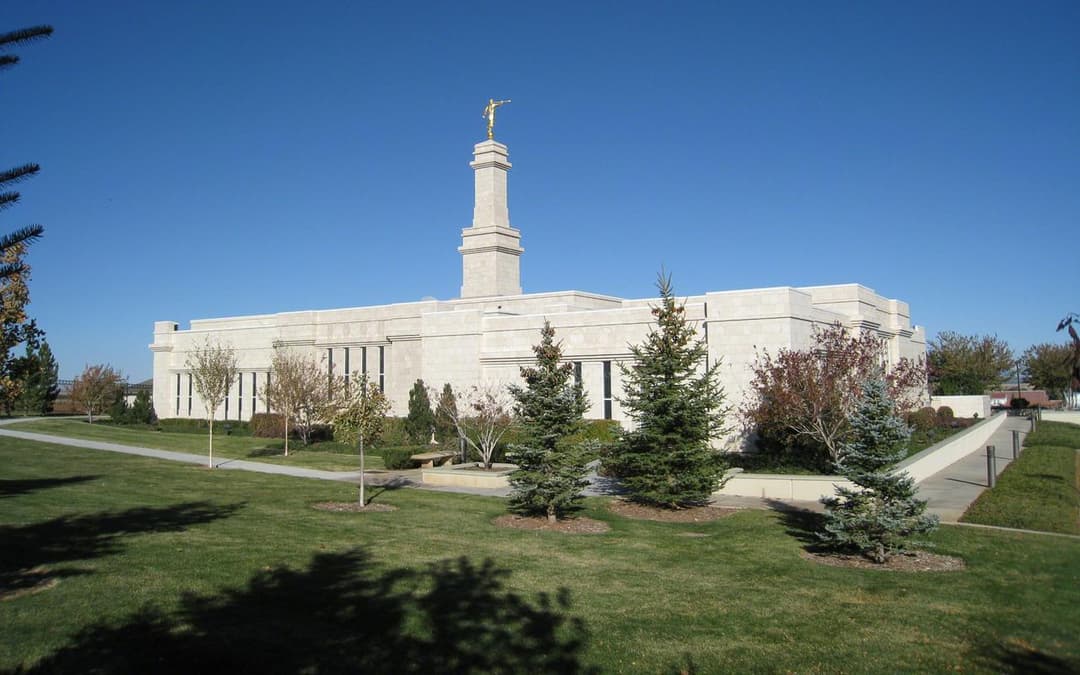 Exterior view of the Monticello Utah Temple and grounds under a clear sky.