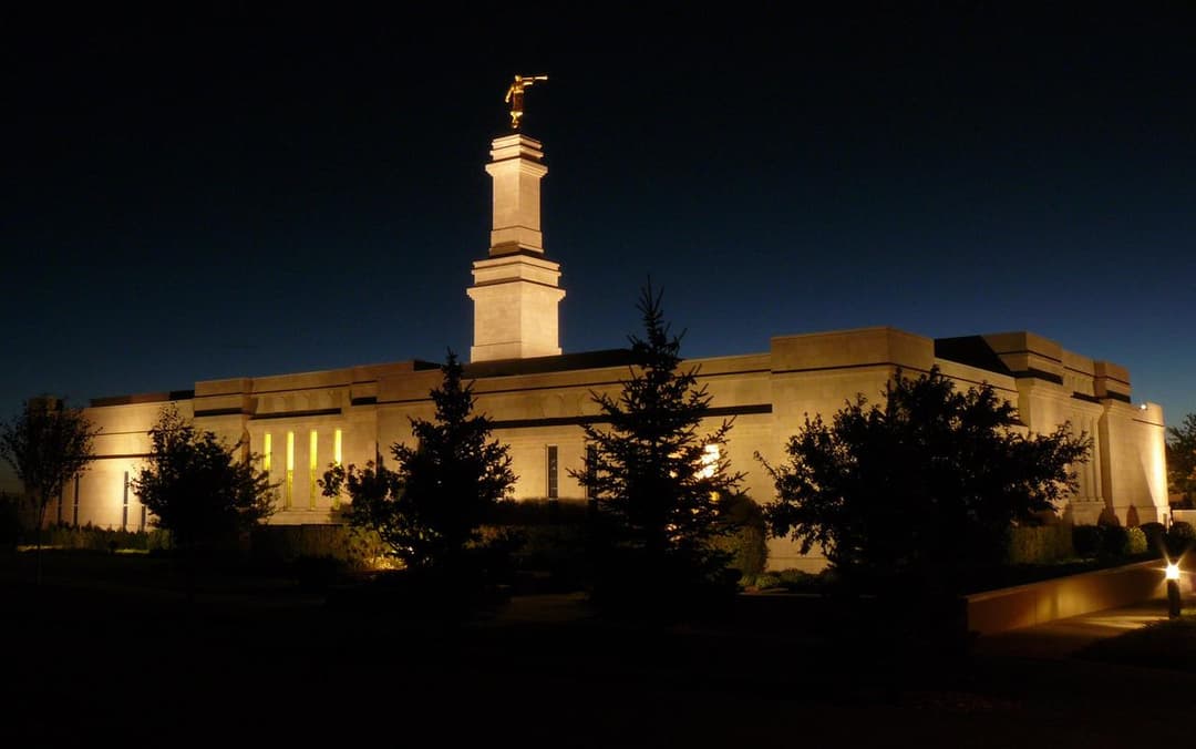 Exterior view of the Monticello Utah Temple illuminated at night.