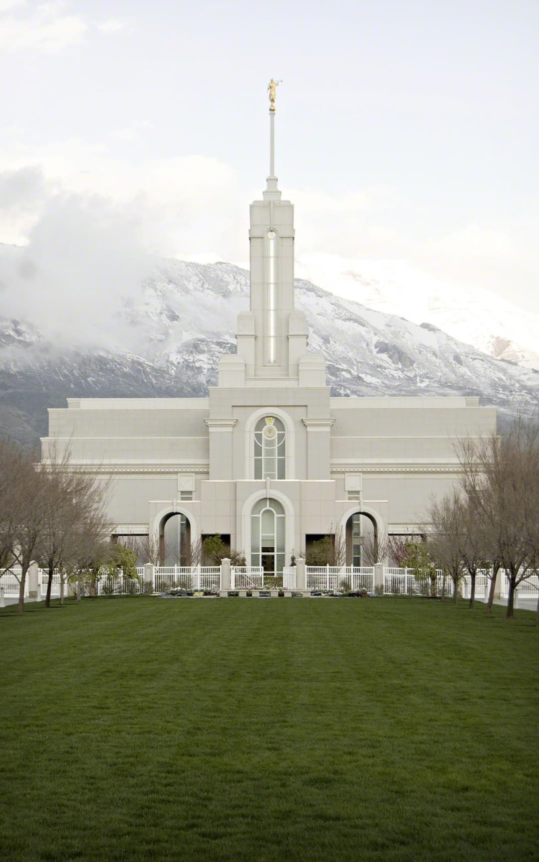 Front view of the Mount Timpanogos Utah Temple against snowy mountains.