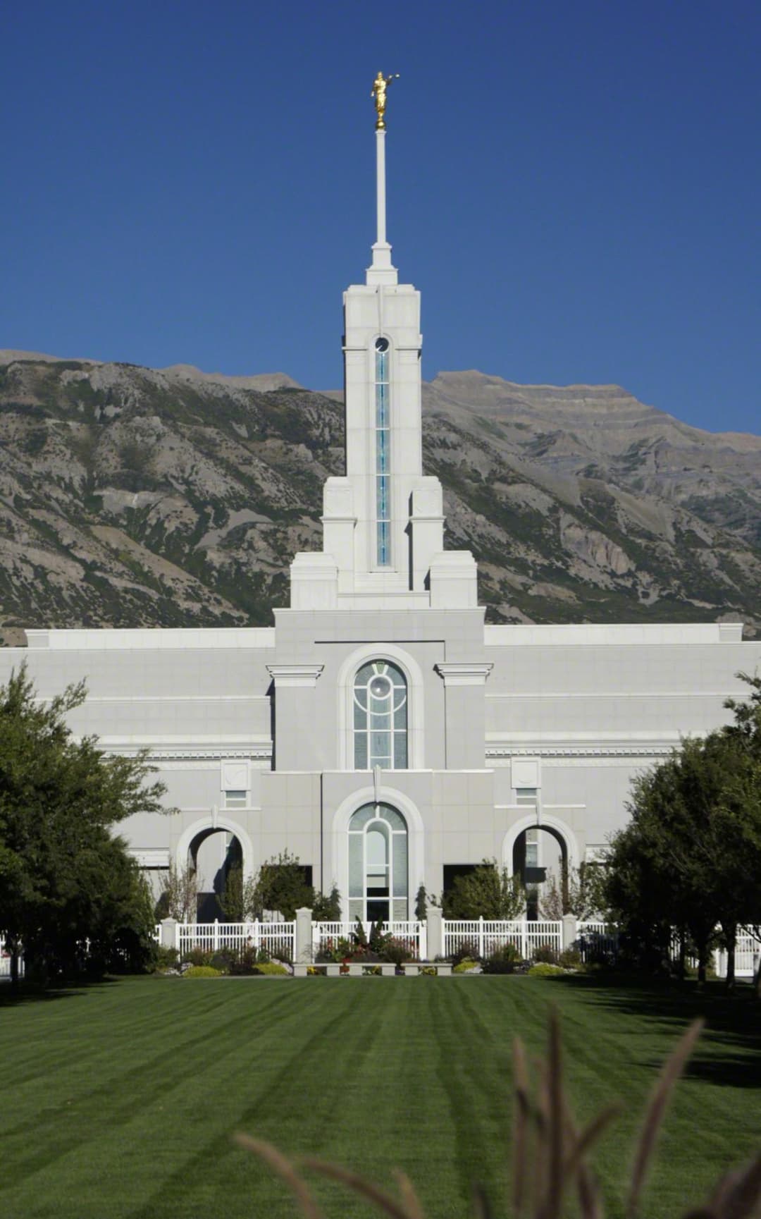 Front facade of the Mount Timpanogos Utah Temple with mountain backdrop.