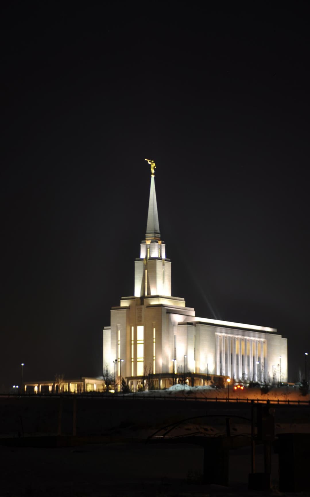 The illuminated exterior of the Oquirrh Mountain Utah Temple at night.